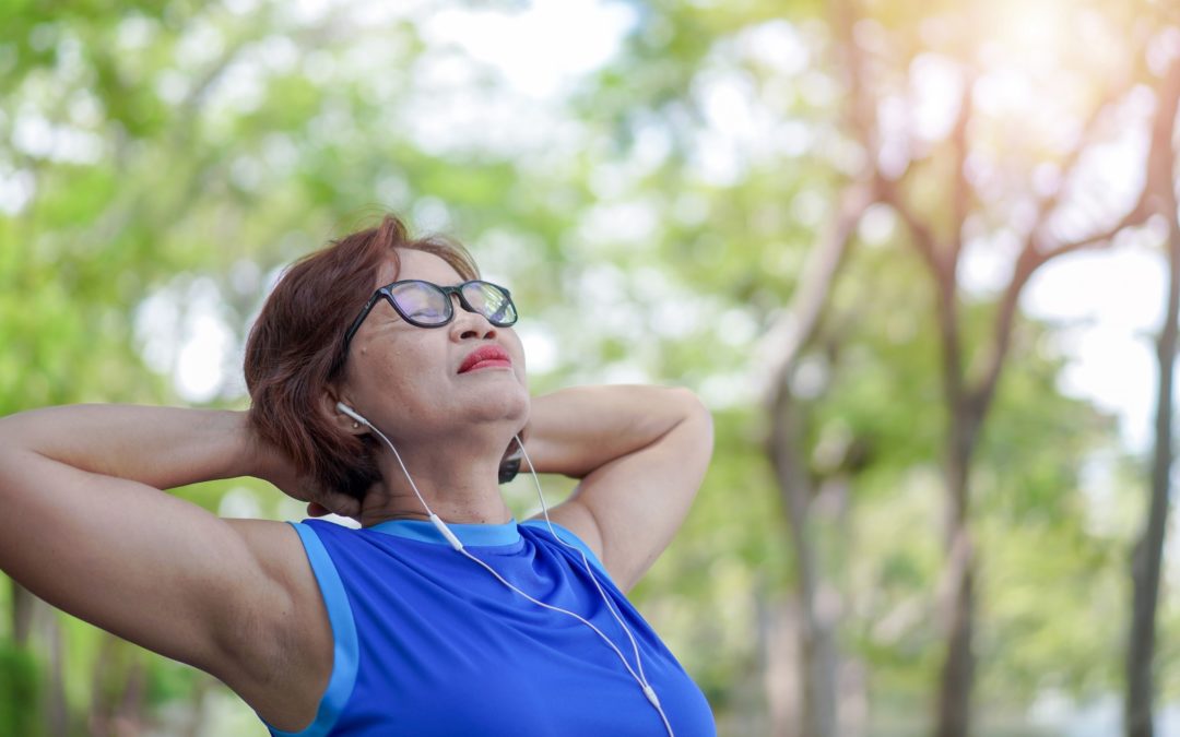 Senior asian woman relaxed listening to music in the park, Exercise sport activity concept